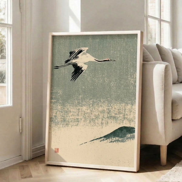 Serene framed poster depicting a soaring crane above a snow-covered landscape in muted earth tones, inspired by traditional Japanese woodblock printing and Japandi aesthetics.
