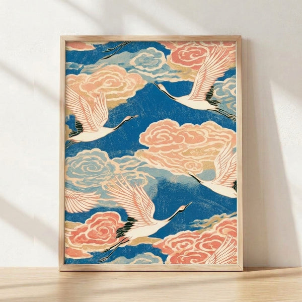 Framed Japanese woodblock print of a graceful crane in flight among soft clouds, rendered in deep blue, cream, and coral pink tones with delicate black outlines.