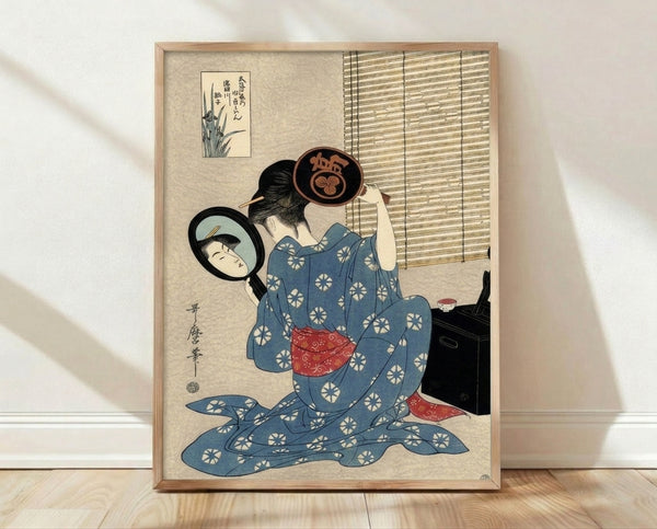 Framed Japanese woodblock print depicting a contemplative geisha in an elegant kimono gazing into her mirror during a beauty ritual, rendered in deep blue, cream, black, and red tones.