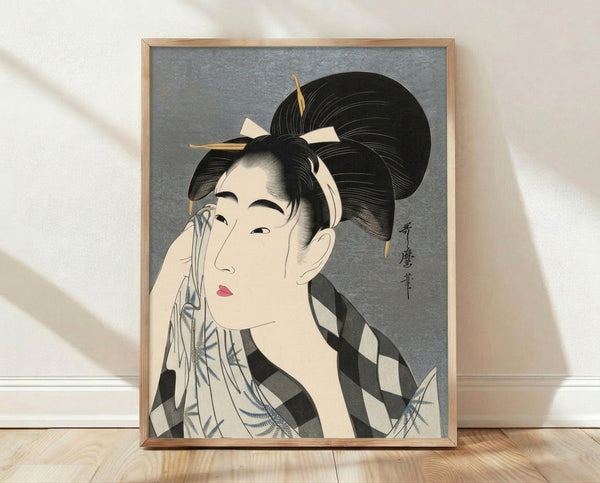 Japanese woodblock print of a geisha in traditional kimono wiping her face, rendered in cream, black, gray, pink and blue tones with elegant, contemplative mood.