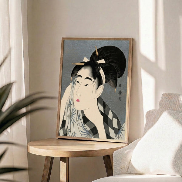 Framed ukiyo-e inspired print portraying an elegant geisha in traditional dress with serene, introspective expression in cream, gray and pink tones.