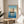 Pale yellow and blue Japanese woodblock art of a traditional junk sailboat on reflective waters, capturing contemplative maritime beauty in framed poster form.