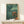 Japanese woodblock-inspired poster featuring opposing samurai armor helmets in deep jewel tones—teal, green, and burnt orange—conveying martial heritage and scholarly aesthetic.