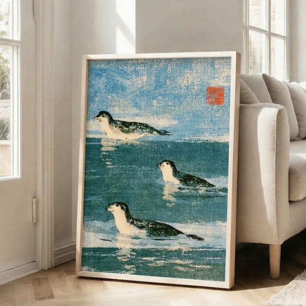 Traditional-inspired seal print with soft white and muted blue hues depicting ocean wildlife, displayed as a framed wall art piece with contemplative, vintage aesthetic.