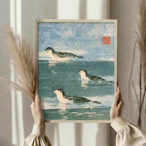 Seals in water portrayed in a Japanese woodblock manner using a palette of dusty blue and dark teal, creating a peaceful naturalistic composition in frame.