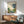 Traditional Japanese aesthetic framed poster featuring a pouring teapot that transforms into a serene stream landscape with bamboo and botanical elements in muted cream, blue, green, and warm gold tones.