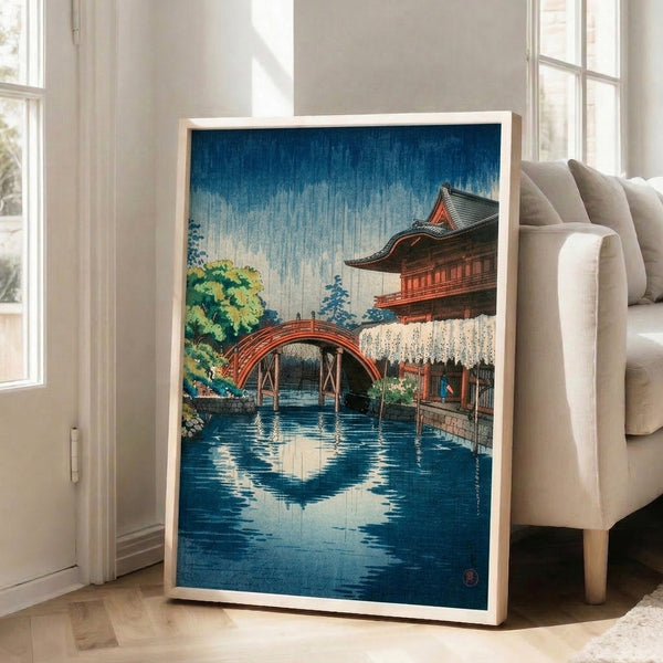 Vintage-style framed print capturing the calm atmosphere of rain at a Japanese temple, with a bridge motif and layered landscape in blue and cream.