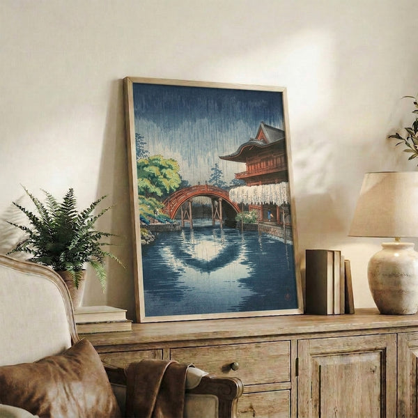 Japanese temple bridge woodblock poster rendered in a serene palette of deep blue, rust-red, and soft greens, evoking a quiet rainy day in Kyoto.