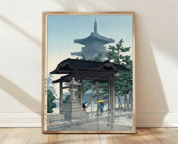 Japanese woodblock print depicting a serene rainy scene at a temple pagoda gate, with figures holding umbrellas beneath trees in muted blue and green tones.
