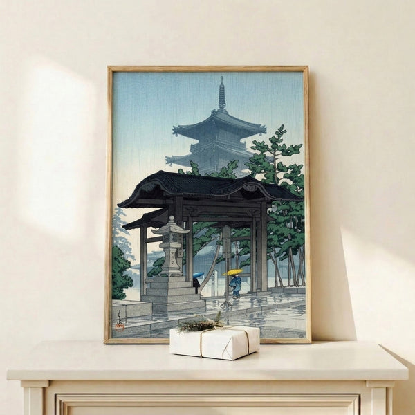 Serene Japanese print on wall displaying umbrella-carrying figures at a rainy pagoda courtyard, captured in calming vintage woodblock aesthetic with gold accents.