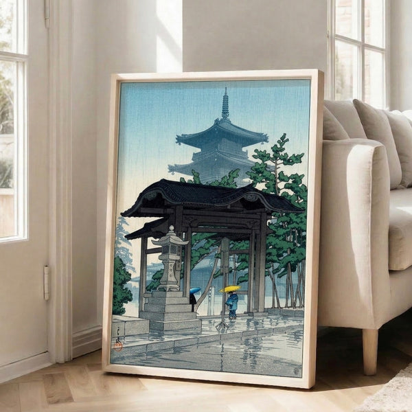 Peaceful Asian wall art showing a rain-soaked temple pagoda with lanterns and figures beneath sheltering trees, in muted jewel tones and cream.