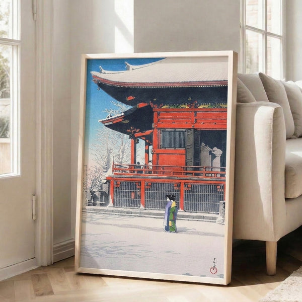 Winter temple scene in traditional Japanese woodblock style: woman in red kimono before snowy building architecture, rendered in blue, white, and charcoal with subtle purple highlights.