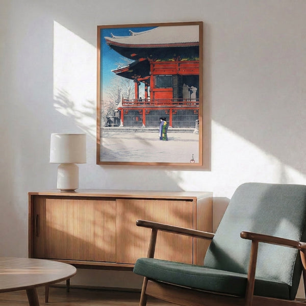 Vintage woodblock-style print featuring temple architecture and a woman in crimson kimono amid winter snow, composed in serene shades of blue, white, black, and accent purple.