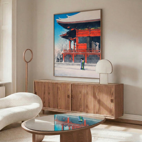 Serene framed woodblock artwork: snow-covered Japanese temple with kimono-dressed figure, rendered in tranquil cerulean blue, bright red, cream white, and charcoal tones.