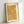 Contemplative botanical scroll design in warm gold and tan tones, blending Japanese textile tradition with Art Nouveau flourishes, shown framed on a wall.