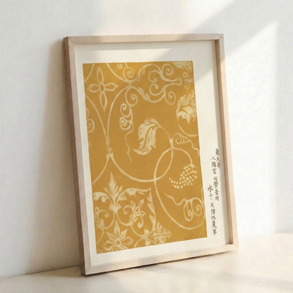 Contemplative botanical scroll design in warm gold and tan tones, blending Japanese textile tradition with Art Nouveau flourishes, shown framed on a wall.