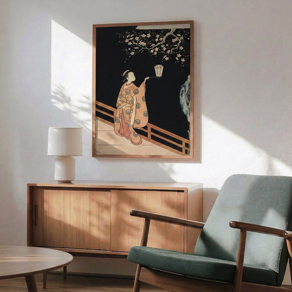Wall-mounted art print showing contemplative figure with lantern framed by cherry blossom branches, Japanese woodblock composition in cream, gold, coral, and muted blue.