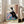 Contemplative portrait of a woman in richly patterned kimono beside a winter window, blending traditional Japanese aesthetic with modern minimalist framing in cream and teal hues.
