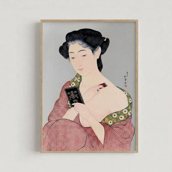 Framed Japanese woodblock portrait of a woman in ornate green and red kimono gazing into a hand mirror, featuring gold details and a contemplative mood against a cream background.