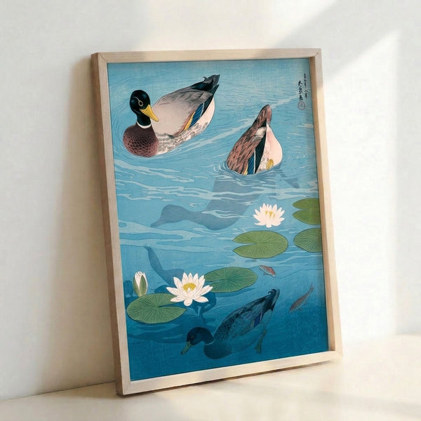 Framed poster art inspired by ukiyo-e traditions showing mallards and koi amid water lilies, rendered in calming light blue and olive green hues with naturalistic detail.