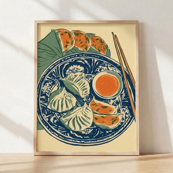 Framed vintage Japanese woodblock-style poster featuring steamed dumplings arranged on a blue willow plate with chopsticks and orange dipping sauce, rendered in cream, navy, and sage tones.