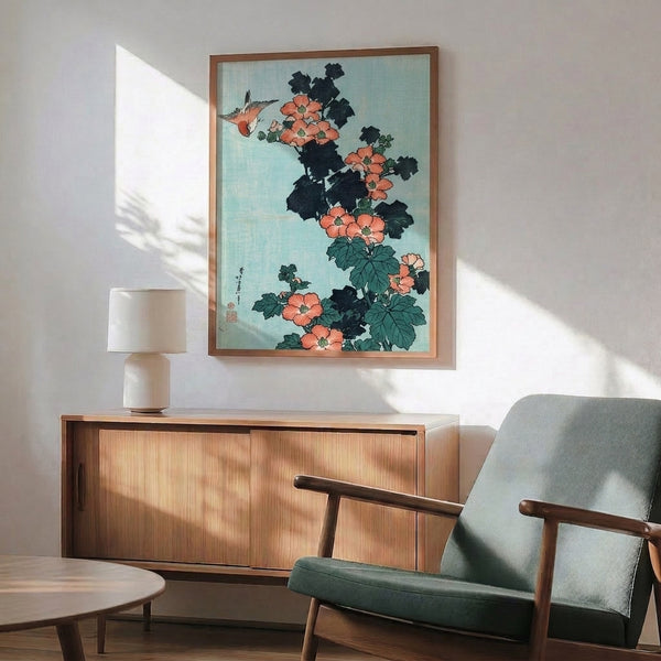 Framed botanical print with a solitary bird surrounded by delicate hibiscus blossoms in muted corals and greens, characterized by the refined linework of Japanese woodblock art.