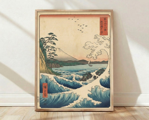 Japanese woodblock seascape print featuring Mount Fuji rising majestically above rolling indigo waves, with a pine tree, boat, and birds in muted teal, cream, and burnt orange tones.