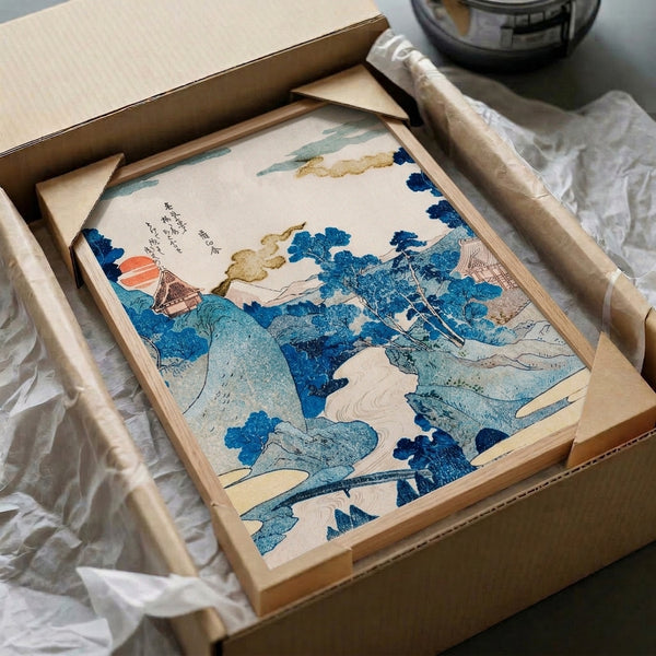 Elegant Asian woodblock landscape artwork framed on wall showing a temple pavilion surrounded by nature and mountains at sunrise, featuring the serene color palette of indigo, rust, and pale cream.