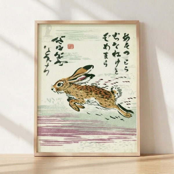 Vintage Japanese woodblock-style poster featuring a leaping hare rendered in cream, tan, and mauve tones, accompanied by elegant dark green calligraphy, framed on a wall.