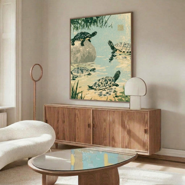 Framed Japanese woodblock print of a turtle on a rocky pond shore surrounded by water plants, rendered in subdued greens, blues, and earth tones with the serene, observational quality of classical Edo-period art.