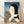Serene Japanese woodblock print framed on wall depicting a woman in traditional kimono combing her hair, rendered in elegant blue, black, and cream tones with contemplative mood.