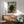 Vintage-inspired jazz artwork showing a bass player in profile set against an art deco cityscape rendered in forest green, charcoal, and warm gold tones.