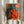 Modern pop art print of intertwined jazz instruments—saxophone and cello—rendered in striking warm and cool colors including orange, red, and teal with gold accents on a dark background.
