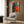 Colorful abstract jazz artwork showcasing a saxophone and double bass in energetic pop art style with vibrant reds, oranges, teals, and gold highlights framed on a wall.
