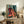 Modern pop art print of musical instruments including saxophone and upright bass in bold teal, burnt orange, and gold tones on deep red, evoking retro jazz culture.
