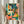 Colorful pop art print showing a celebratory street musician playing trumpet amid tropical elements, rendered in vibrant turquoise, pink, orange, and cream tones on a wall.