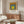 Contemplative color field artwork showing concentric squares in warm ochre, soft gray, and cool teal arranged in balanced geometric progression.