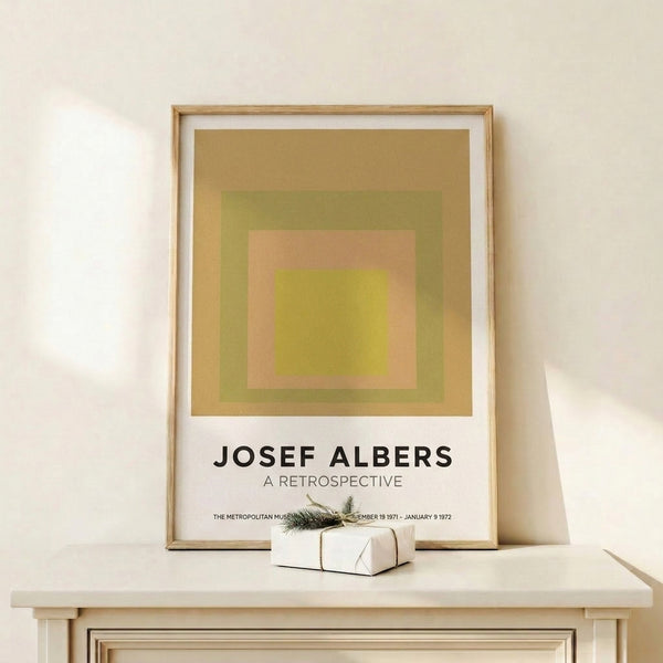 Abstract geometric print of layered squares in peach, chartreuse, and olive tones hung as framed wall art.