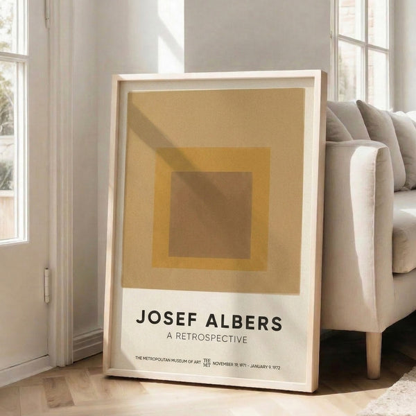 Framed minimalist poster with concentric square forms in soft ochre, taupe, and cream, reflecting the contemplative essence of Bauhaus art.