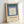 Modern framed poster displaying layered nested squares in a serene palette of sage green, mauve, teal, and cream, exemplifying minimalist Bauhaus design principles.