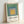 Mid-century modern poster displaying Albers' iconic nested square composition in muted tones of sage, warm gray, and soft blue, evoking calm and balance.