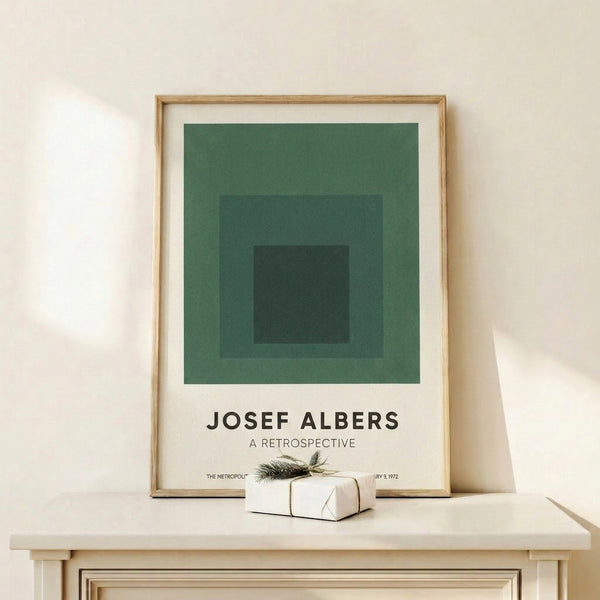 Geometric wall art displaying centered nested squares in cream, sage green, forest green, and charcoal—a serene exploration of form and color balance.