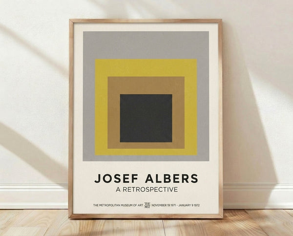 Nested squares in shades of gray, yellow, tan, and charcoal form a meditative geometric composition in the Bauhaus minimalist style.