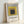 Minimalist square composition with layered rectangles in yellow, gray, and tan hues, characteristic of Bauhaus design principles.