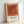 Geometric abstract poster displaying layered squares in rust and terracotta tones, exemplifying minimalist color theory and meditative design.