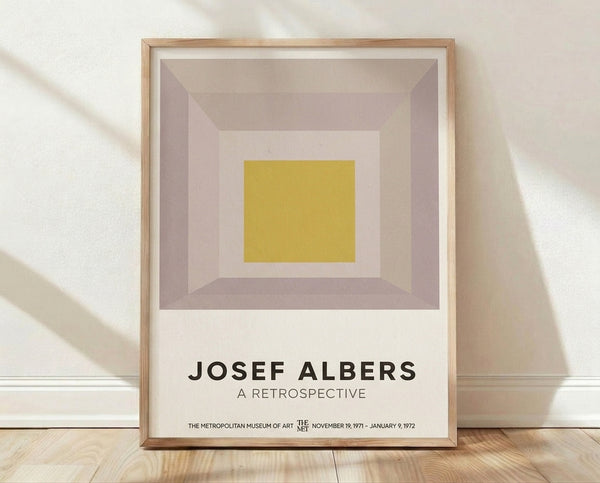 Minimalist Bauhaus poster featuring nested squares in cream, mauve, mustard yellow, and taupe creating a meditative geometric composition framed on a wall.