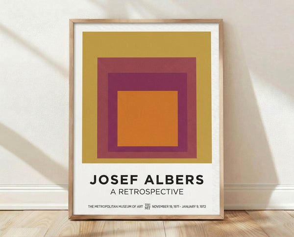 Concentric squares in warm gold, burgundy, and plum tones arranged in a minimalist Bauhaus composition, creating a meditative geometric artwork framed as a poster on a wall.