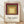 Concentric squares in burgundy, olive green, tan, and cream create a meditative Bauhaus composition on a framed poster.