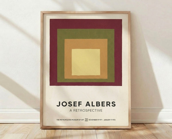 Concentric squares in burgundy, olive green, tan, and cream create a meditative Bauhaus composition on a framed poster.
