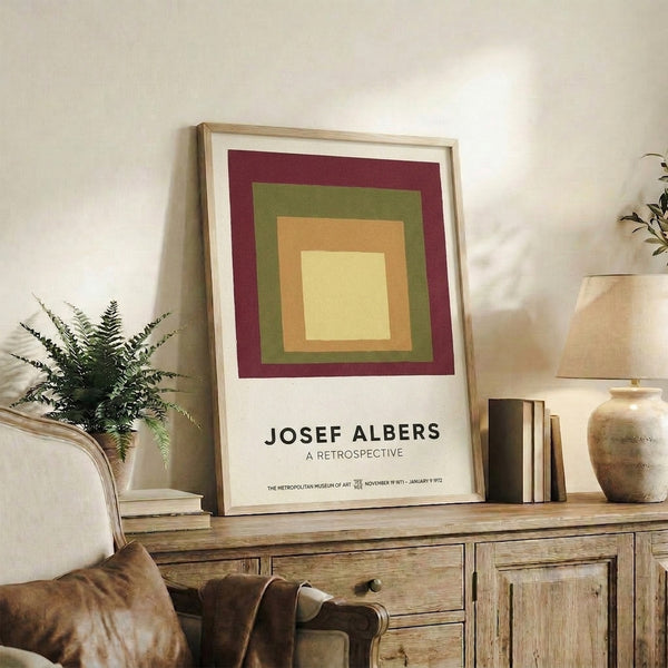 Mid-century modern framed poster with abstract squares in cream, pale yellow, olive green, and burgundy creating visual balance.
